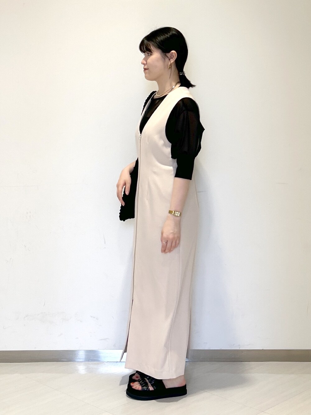 ブラック系のショルダーバッグ、ブラウン系のワンピース、ブラック系のTシャツ/カットソーを着用したレディースの夏コーディネートの2枚目の写真