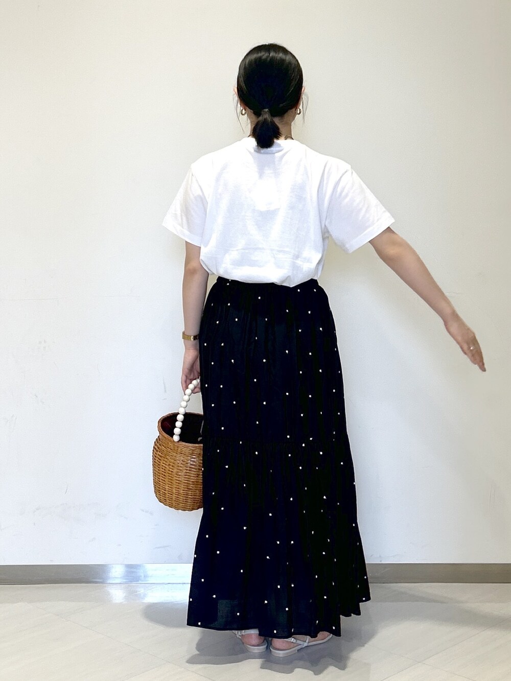 ホワイト系のTシャツ/カットソー、ブラック系のスカート、ブラウン系のかごバッグを着用したレディースの夏コーディネートの4枚目の写真