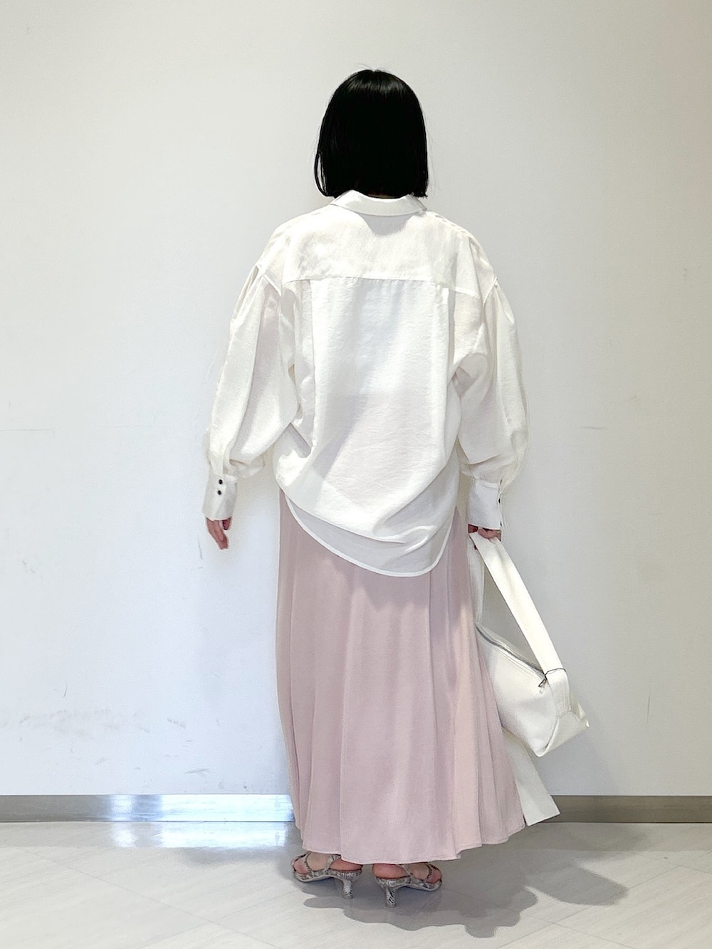 ホワイト系のショルダーバッグ、ブラウン系のサンダル、ピンク系のスカートを着用したレディースの春コーディネートの3枚目の写真