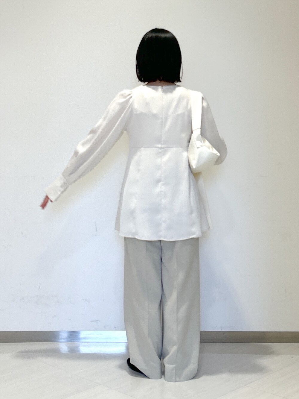 ホワイト系のシャツ/ブラウス、ホワイト系のショルダーバッグ、ベージュ系のスラックスを着用したレディースの春コーディネートの3枚目の写真