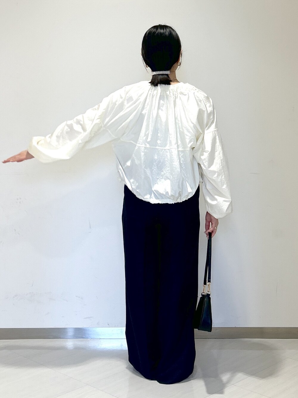 ホワイト系のTシャツ/カットソー、ホワイト系のブルゾン、ブラック系のその他パンツを着用したレディースの春コーディネートの5枚目の写真