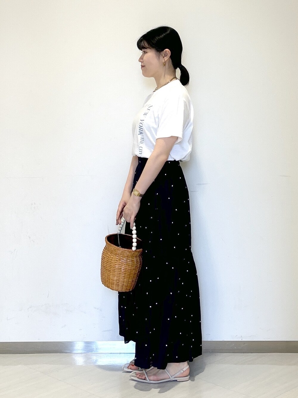 ホワイト系のTシャツ/カットソー、ブラック系のスカート、ブラウン系のかごバッグを着用したレディースの夏コーディネートの3枚目の写真