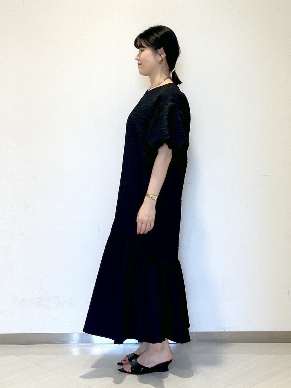 ブラック系のワンピース、ブラック系のサンダル、ブラック系のショルダーバッグを着用したレディースの夏コーディネートの2枚目の写真