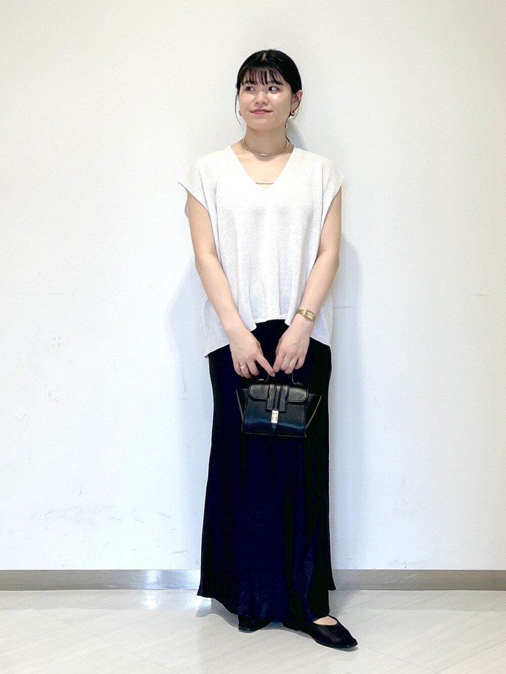 ベージュ系のキャミソール、ホワイト系のニット/セーター、ブラック系のショルダーバッグを着用したレディースの夏コーディネートの6枚目の写真