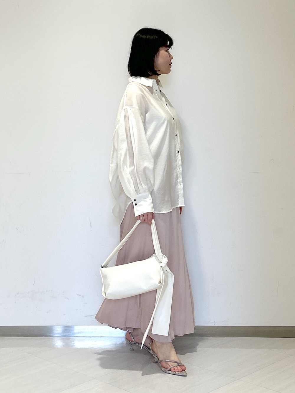 ホワイト系のショルダーバッグ、ブラウン系のサンダル、ピンク系のスカートを着用したレディースの春コーディネートの4枚目の写真
