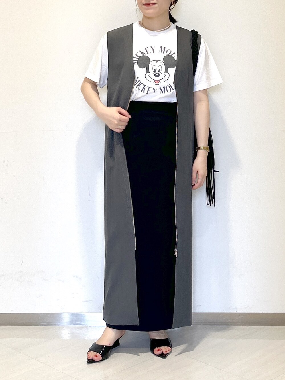 ブラック系のサンダル、ブラック系のスカート、ブラック系のショルダーバッグを着用したレディースの夏コーディネートの2枚目の写真