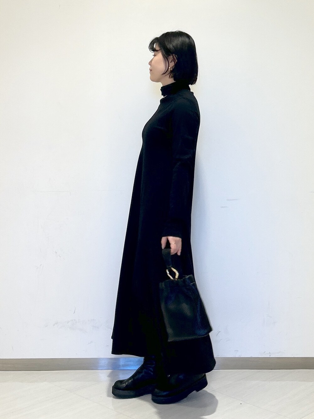 ホワイト系のワンピース、ブラック系のショルダーバッグ、グリーン系のカーディガン/ボレロを着用したレディースの冬コーディネートの6枚目の写真