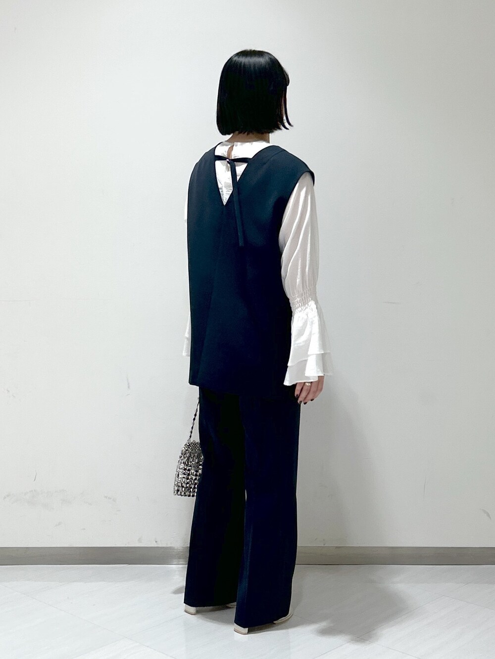 ホワイト系のシャツ/ブラウス、ブルー系のパンツドレス、シルバー系のショルダーバッグを着用したレディースの冬コーディネートの4枚目の写真