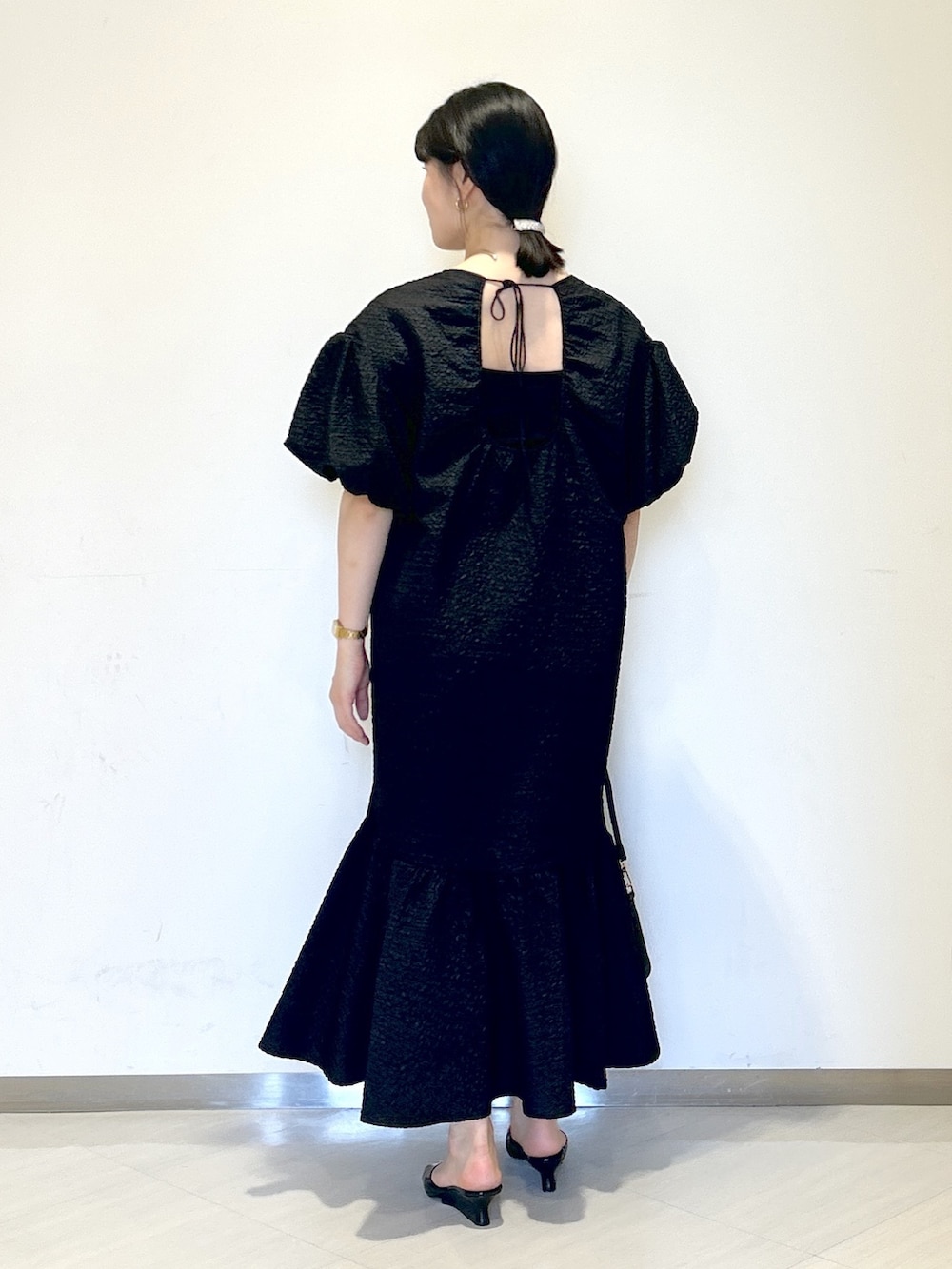 ブラック系のワンピース、ブラック系のサンダル、ブラック系のショルダーバッグを着用したレディースの夏コーディネートの3枚目の写真