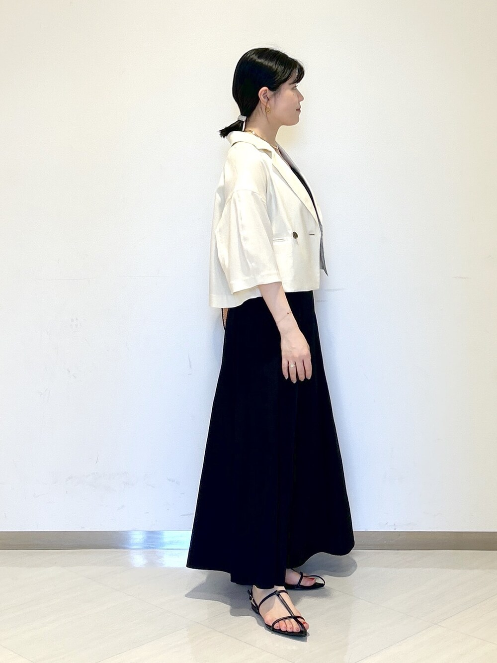 ブラック系のタンクトップ、ホワイト系のテーラードジャケット、ブラック系のショルダーバッグを着用したレディースの夏コーディネートの5枚目の写真