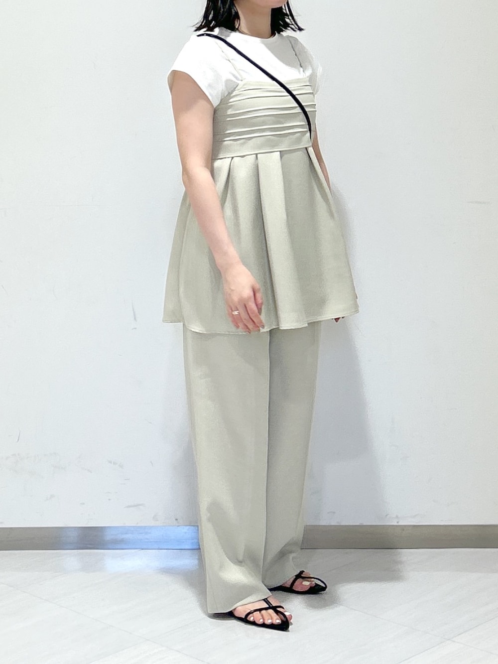 ベージュ系のスラックス、ブラック系のサンダル、ベージュ系のキャミソールを着用したレディースの夏コーディネートの4枚目の写真