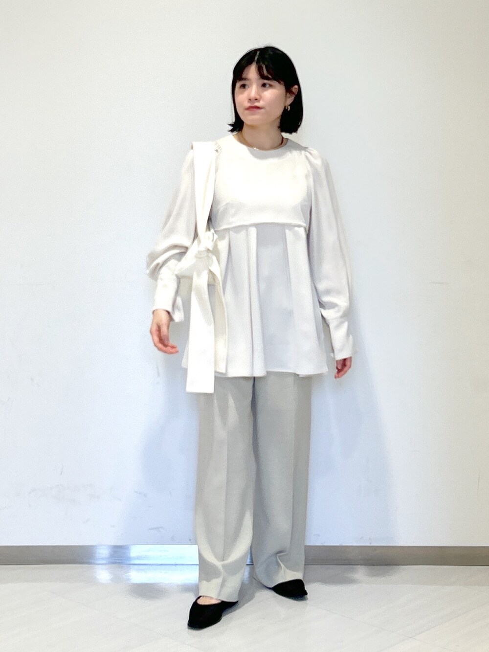 ホワイト系のシャツ/ブラウス、ホワイト系のショルダーバッグ、ベージュ系のスラックスを着用したレディースの春コーディネートの5枚目の写真