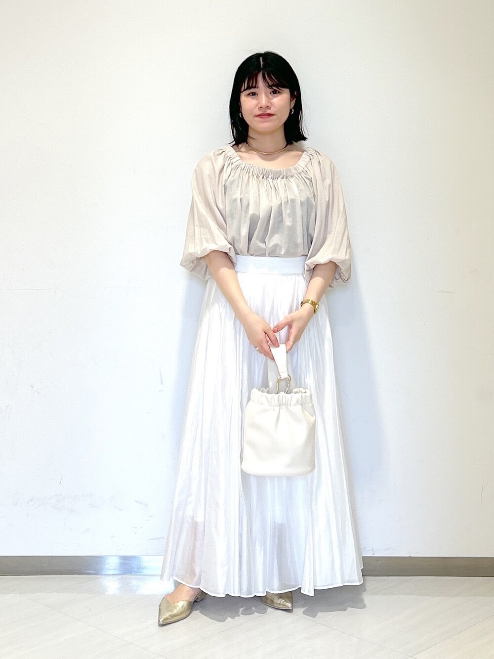 ホワイト系のスカート、ベージュ系のシャツ/ブラウス、ホワイト系のショルダーバッグを着用したレディースの夏コーディネートの5枚目の写真