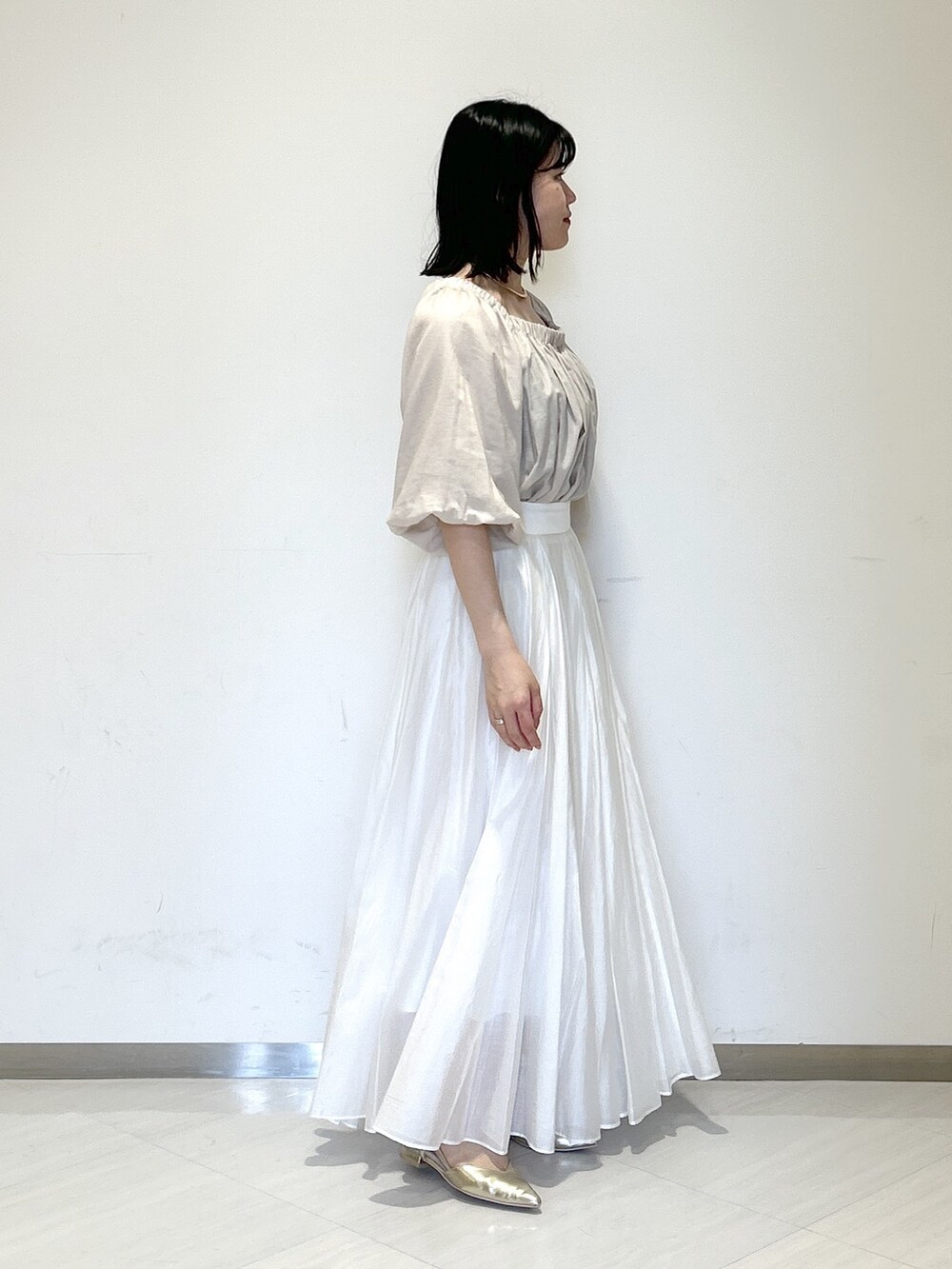 ホワイト系のスカート、ベージュ系のシャツ/ブラウス、ホワイト系のショルダーバッグを着用したレディースの夏コーディネートの4枚目の写真