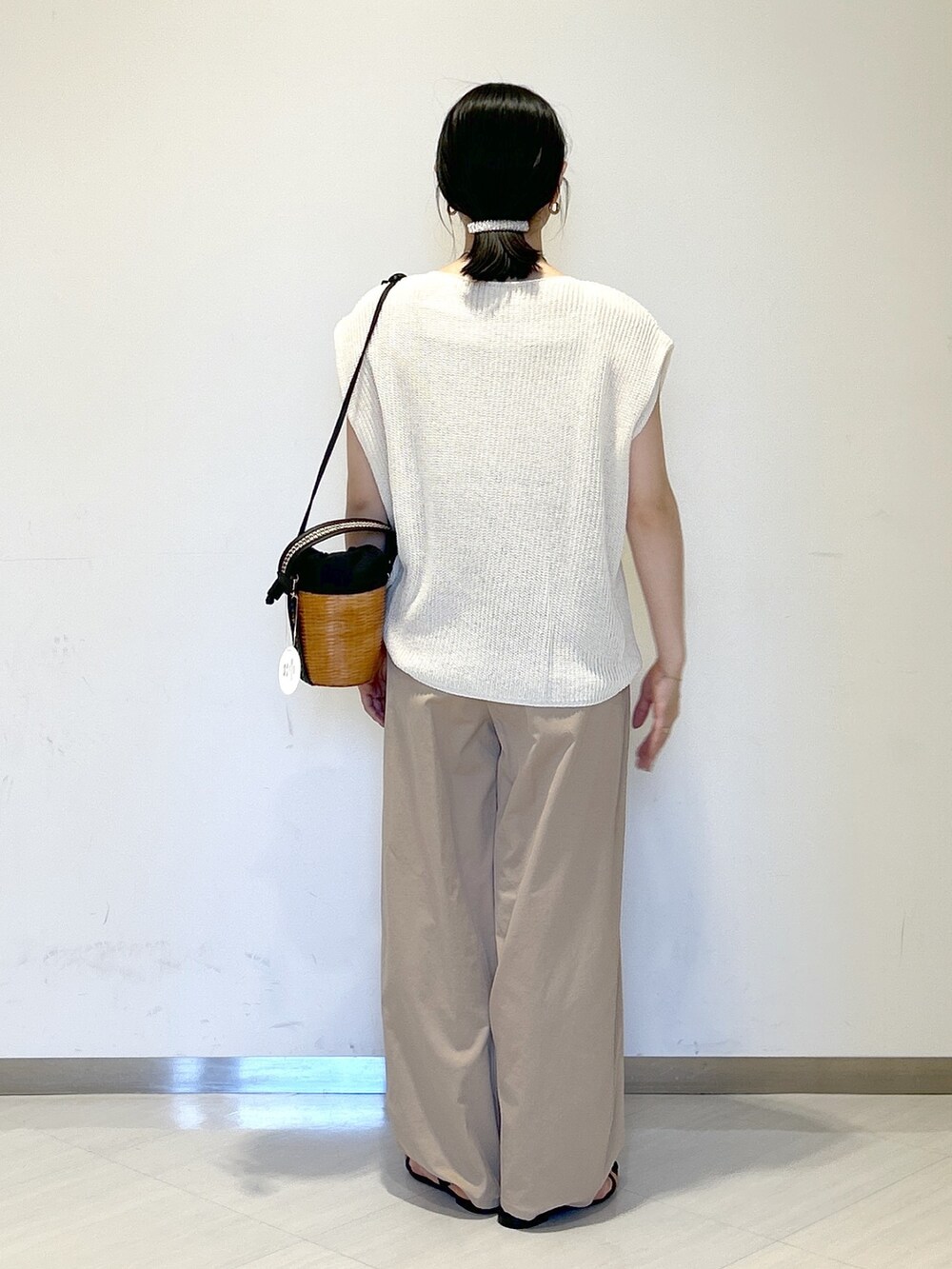 ホワイト系のニット/セーター、ブラック系のショルダーバッグ、イエロー系のその他パンツを着用したレディースの夏コーディネートの4枚目の写真