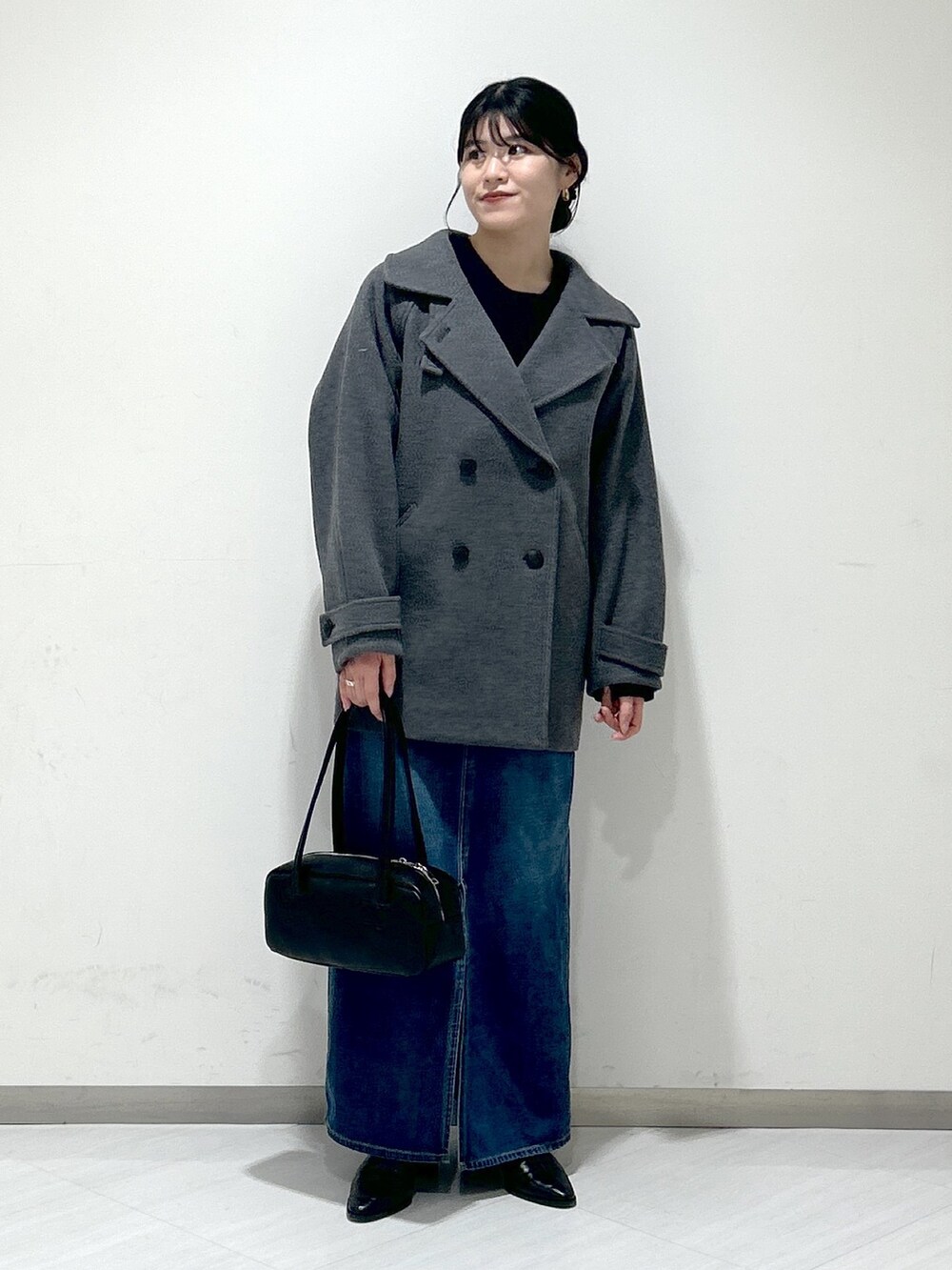 ブルー系のニット/セーター、グレー系のピーコート、ブルー系のデニムスカートを着用したレディースの冬コーディネートの4枚目の写真