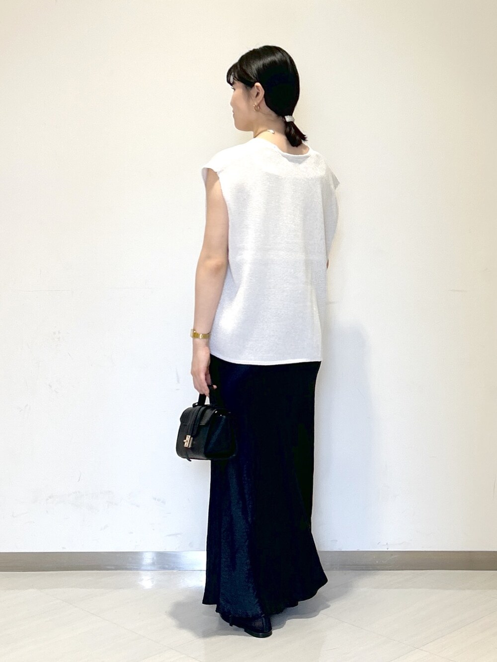 ベージュ系のキャミソール、ホワイト系のニット/セーター、ブラック系のショルダーバッグを着用したレディースの夏コーディネートの3枚目の写真