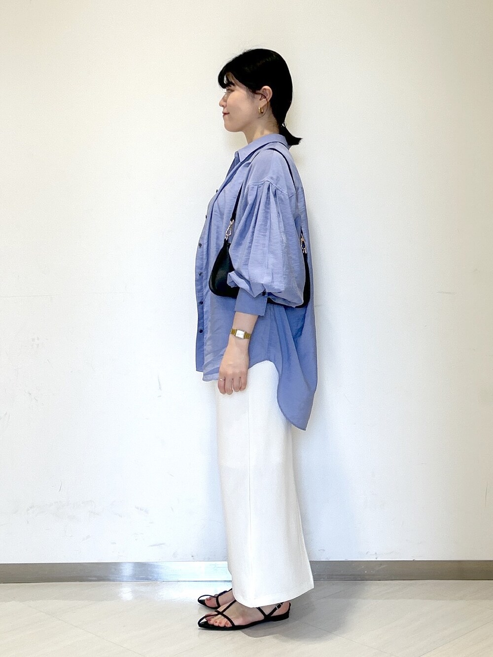 ブラック系のショルダーバッグ、ホワイト系のタンクトップ、ブルー系のシャツ/ブラウスを着用したレディースの夏コーディネートの3枚目の写真