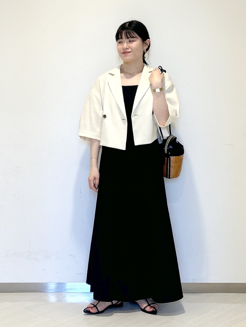 ブラック系のタンクトップ、ホワイト系のテーラードジャケット、ブラック系のショルダーバッグを着用したレディースの夏コーディネートの6枚目の写真