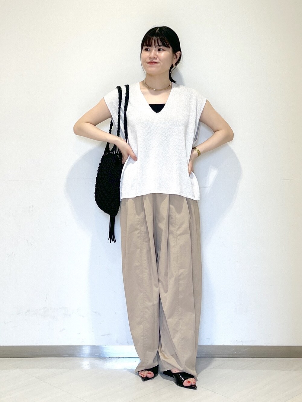 ブラック系のタンクトップ、ブラック系のショルダーバッグ、イエロー系のその他パンツを着用したレディースの夏コーディネートの6枚目の写真