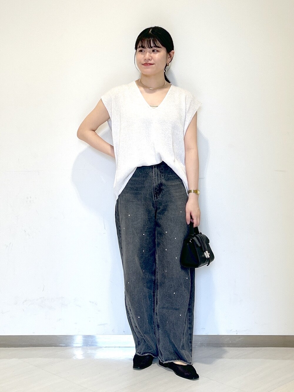 ベージュ系のキャミソール、ホワイト系のニット/セーター、ブラック系のショルダーバッグを着用したレディースの夏コーディネートの2枚目の写真