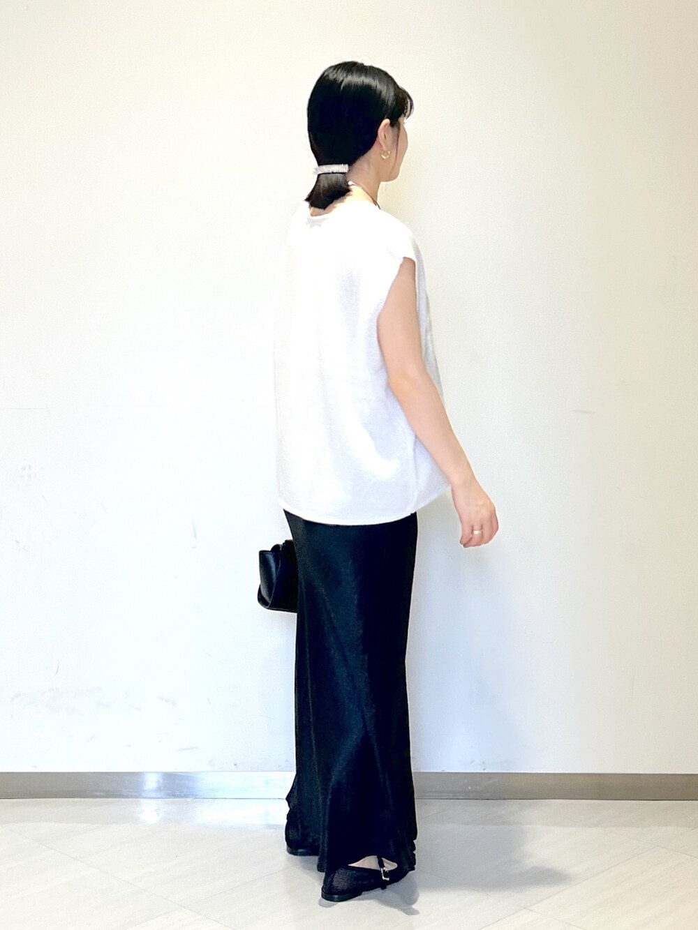 ベージュ系のキャミソール、ホワイト系のニット/セーター、ブラック系のショルダーバッグを着用したレディースの夏コーディネートの5枚目の写真