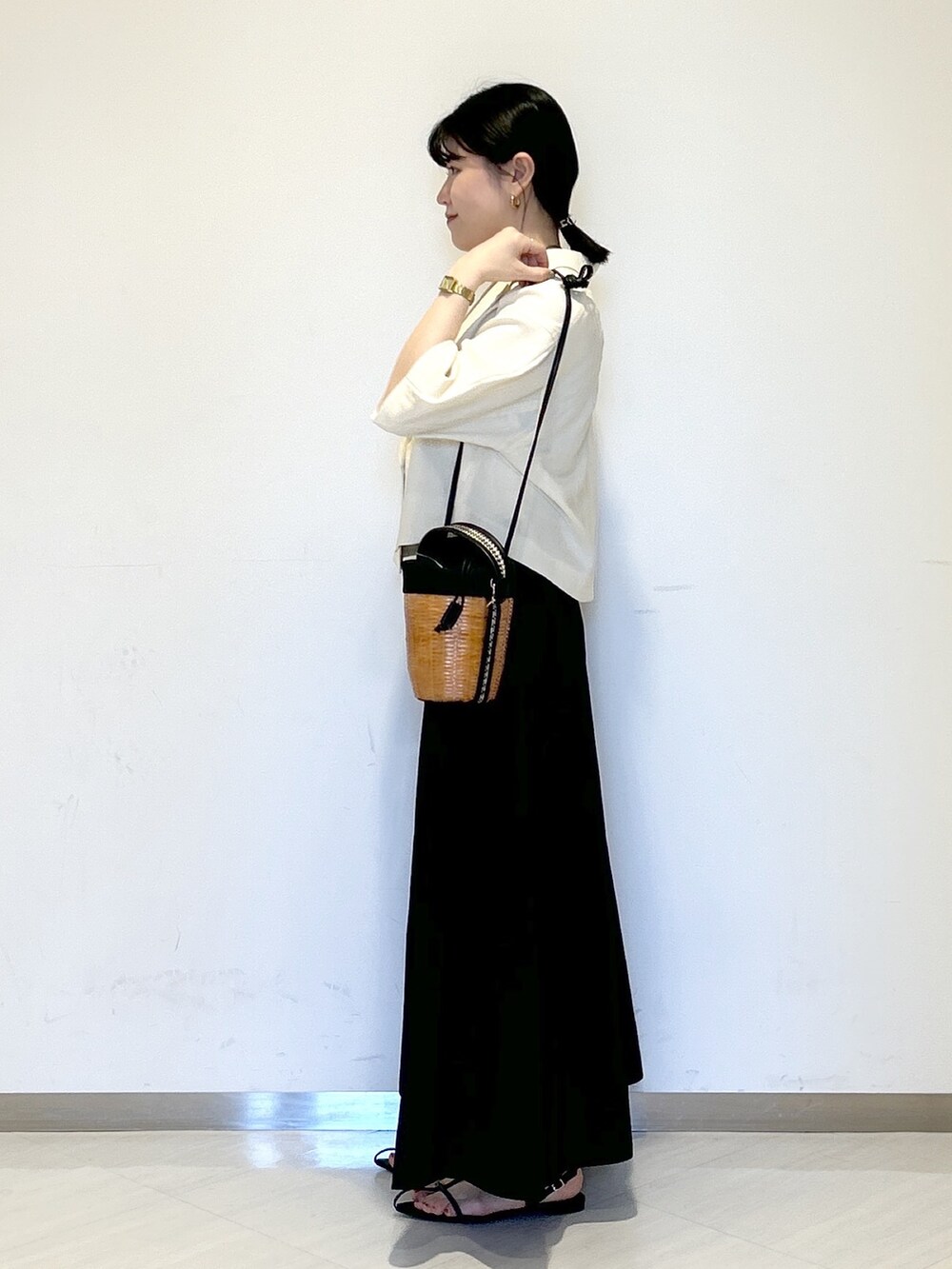 ブラック系のタンクトップ、ホワイト系のテーラードジャケット、ブラック系のショルダーバッグを着用したレディースの夏コーディネートの3枚目の写真