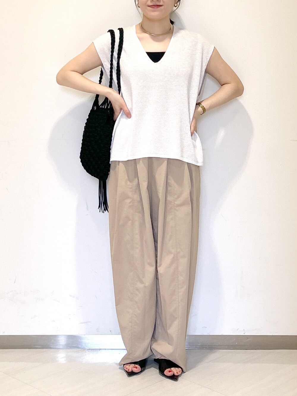 ブラック系のタンクトップ、ブラック系のショルダーバッグ、イエロー系のその他パンツを着用したレディースの夏コーディネートの2枚目の写真