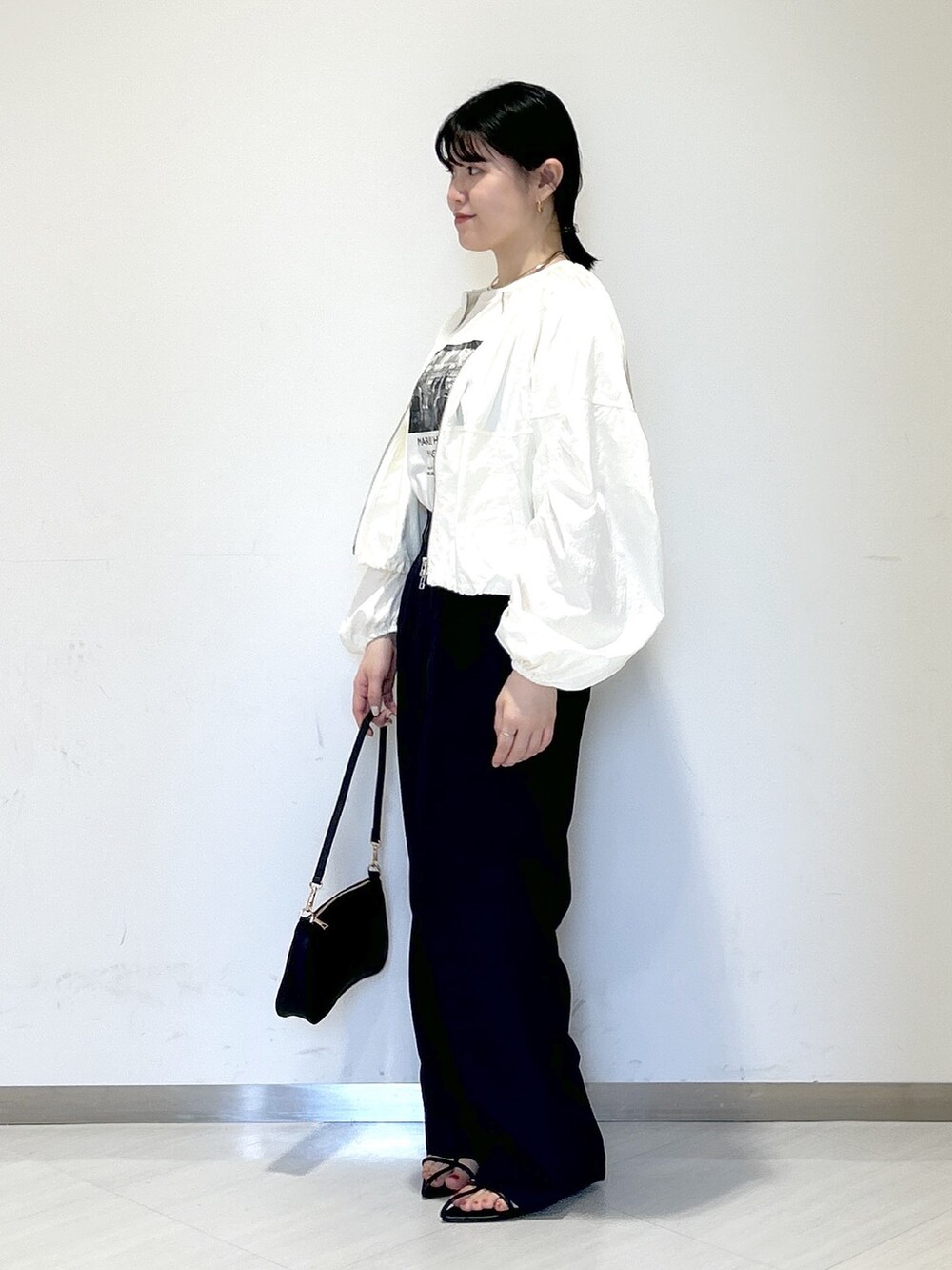 ホワイト系のTシャツ/カットソー、ホワイト系のブルゾン、ブラック系のその他パンツを着用したレディースの春コーディネートの3枚目の写真