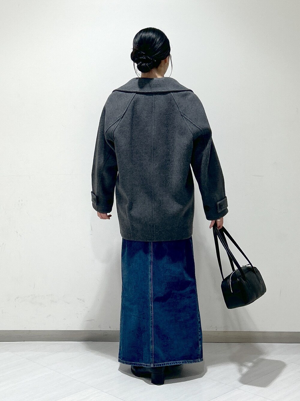 ブルー系のニット/セーター、グレー系のピーコート、ブルー系のデニムスカートを着用したレディースの冬コーディネートの3枚目の写真