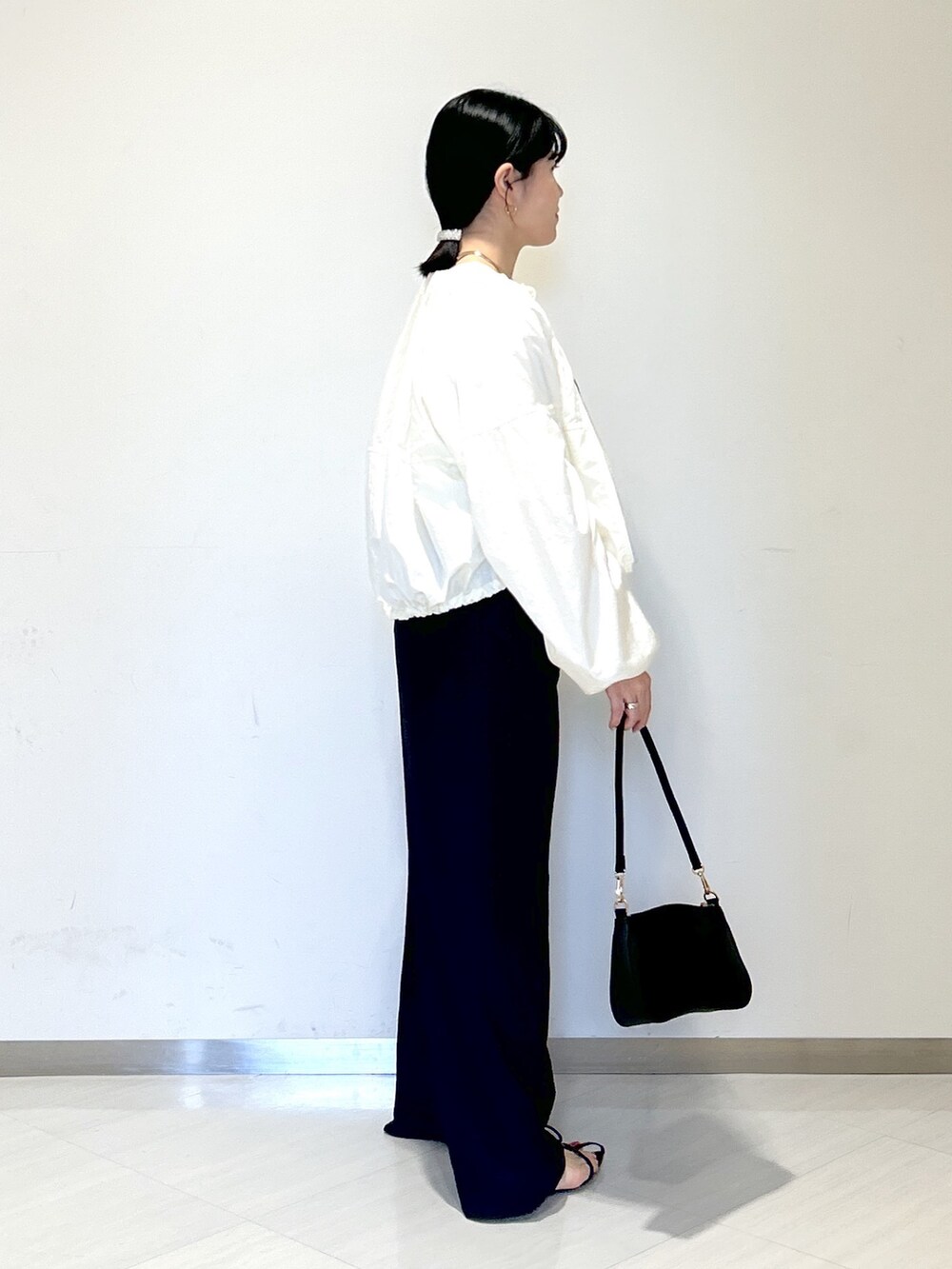 ホワイト系のTシャツ/カットソー、ホワイト系のブルゾン、ブラック系のその他パンツを着用したレディースの春コーディネートの6枚目の写真