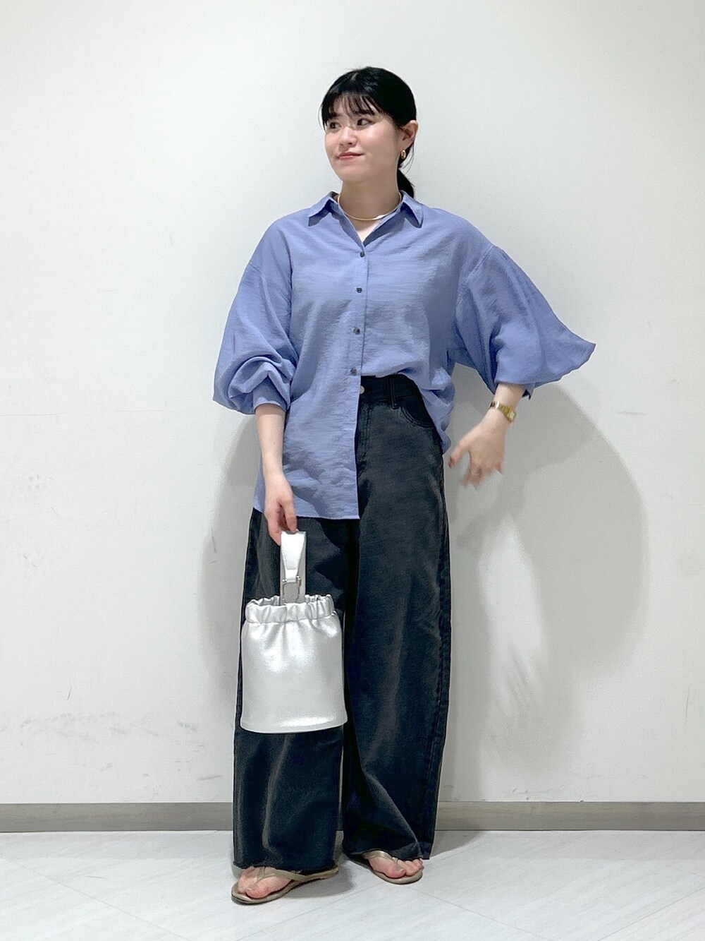 グレー系のデニムパンツ、ブルー系のシャツ/ブラウス、シルバー系のショルダーバッグを着用したレディースの夏コーディネートの2枚目の写真