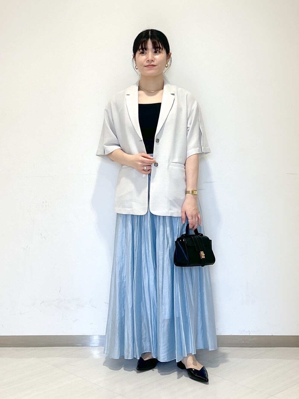 グレー系のテーラードジャケット、ブラック系のタンクトップ、ブラック系のショルダーバッグを着用したレディースの夏コーディネートの5枚目の写真