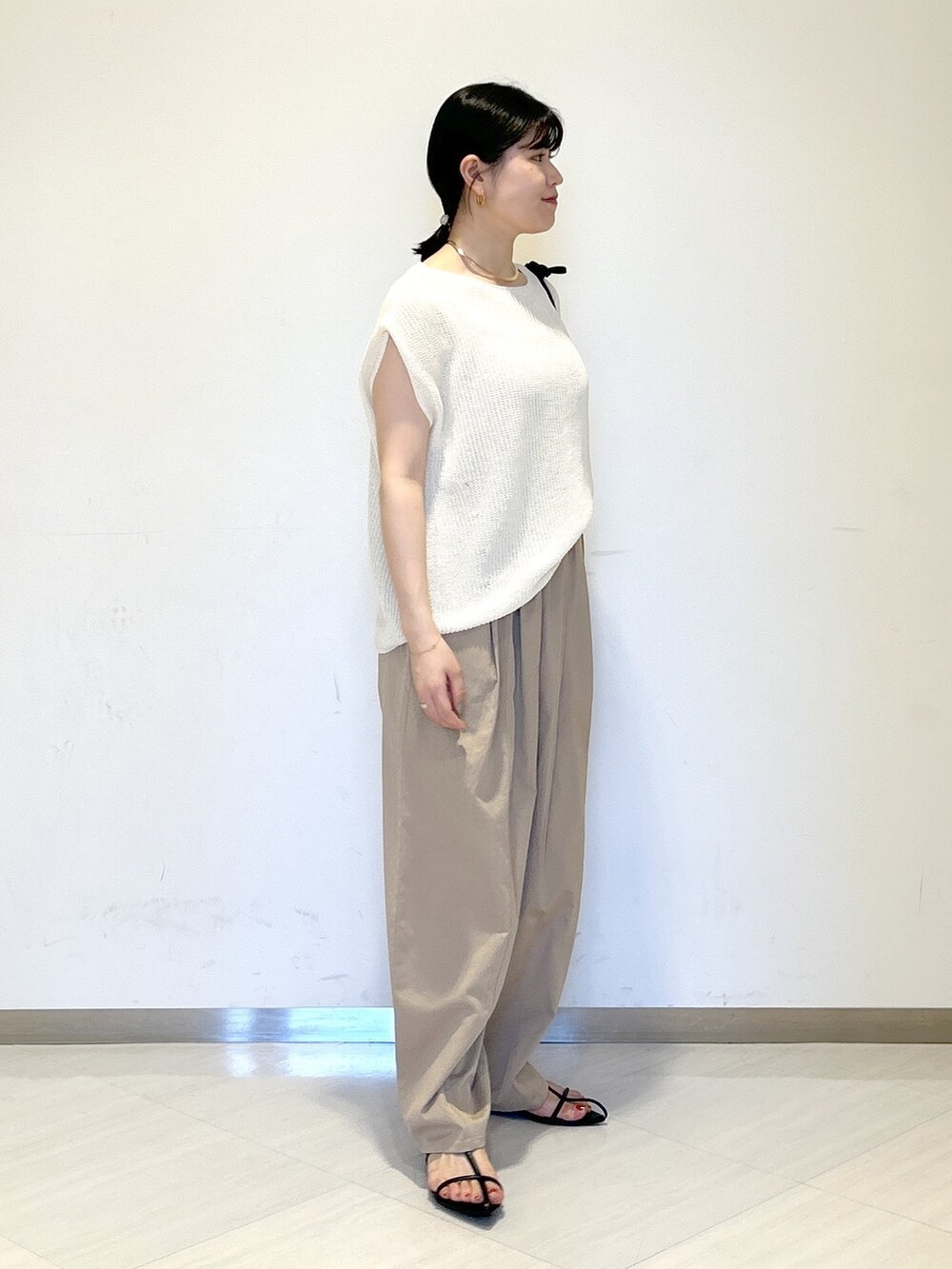 ホワイト系のニット/セーター、ブラック系のショルダーバッグ、イエロー系のその他パンツを着用したレディースの夏コーディネートの6枚目の写真