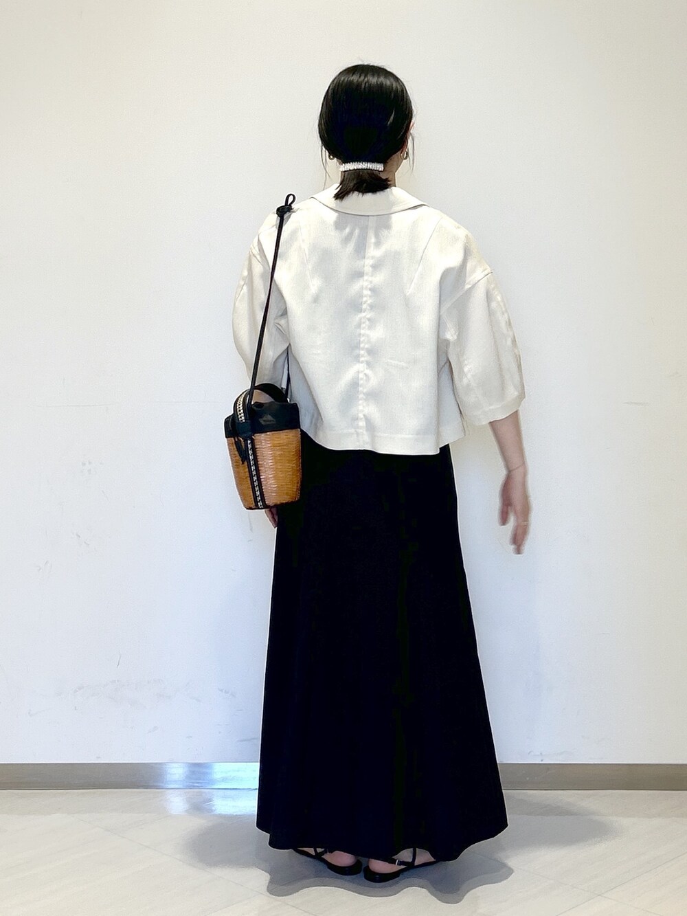 ブラック系のタンクトップ、ホワイト系のテーラードジャケット、ブラック系のショルダーバッグを着用したレディースの夏コーディネートの4枚目の写真