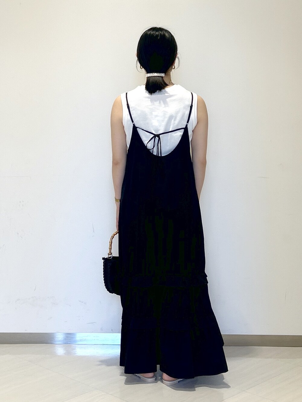 ブラック系のワンピース、ブラック系のショルダーバッグ、ホワイト系のサンダルを着用したレディースの夏コーディネートの4枚目の写真