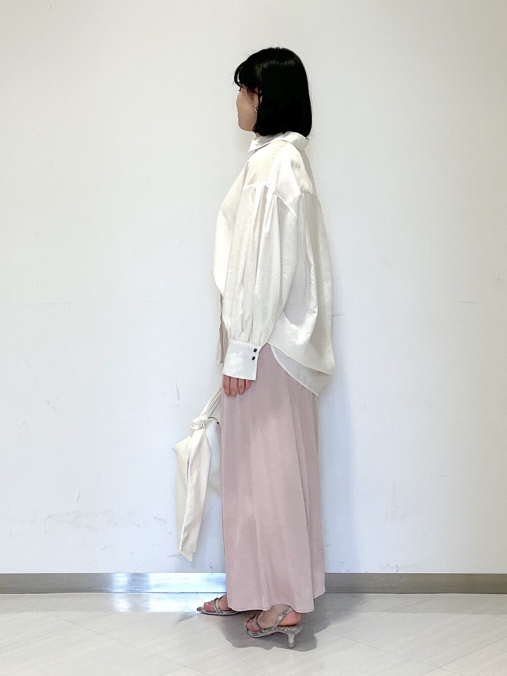 ホワイト系のショルダーバッグ、ブラウン系のサンダル、ピンク系のスカートを着用したレディースの春コーディネートの2枚目の写真