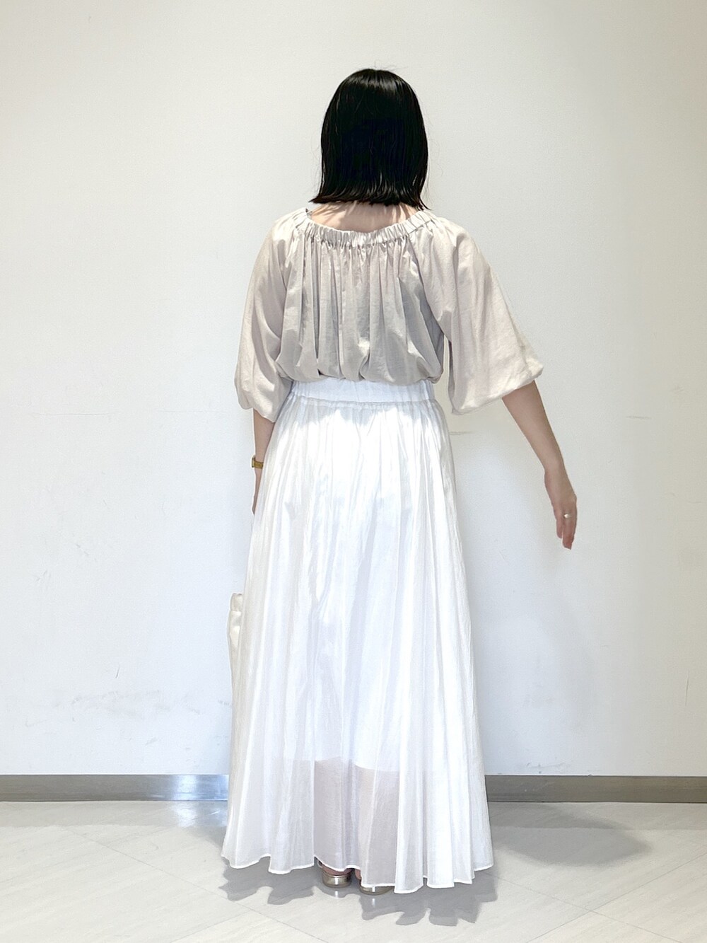 ホワイト系のスカート、ベージュ系のシャツ/ブラウス、ホワイト系のショルダーバッグを着用したレディースの夏コーディネートの3枚目の写真