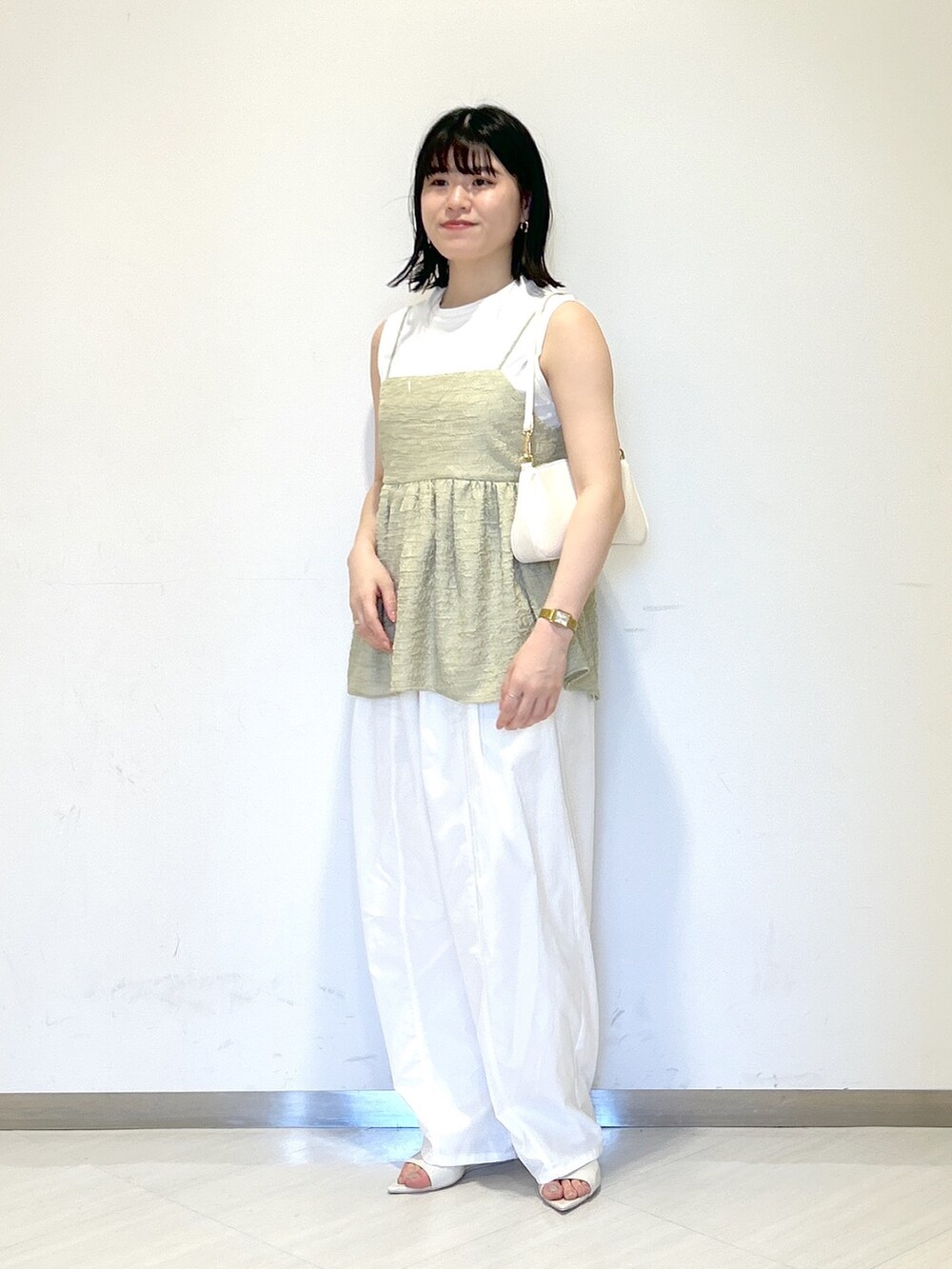 ホワイト系のその他パンツ、グリーン系のTシャツ/カットソー、ホワイト系のショルダーバッグを着用したレディースの夏コーディネートの2枚目の写真