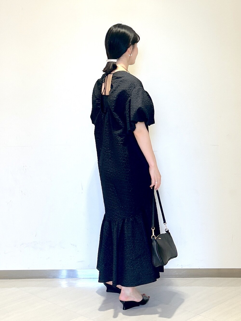 ブラック系のワンピース、ブラック系のサンダル、ブラック系のショルダーバッグを着用したレディースの夏コーディネートの4枚目の写真