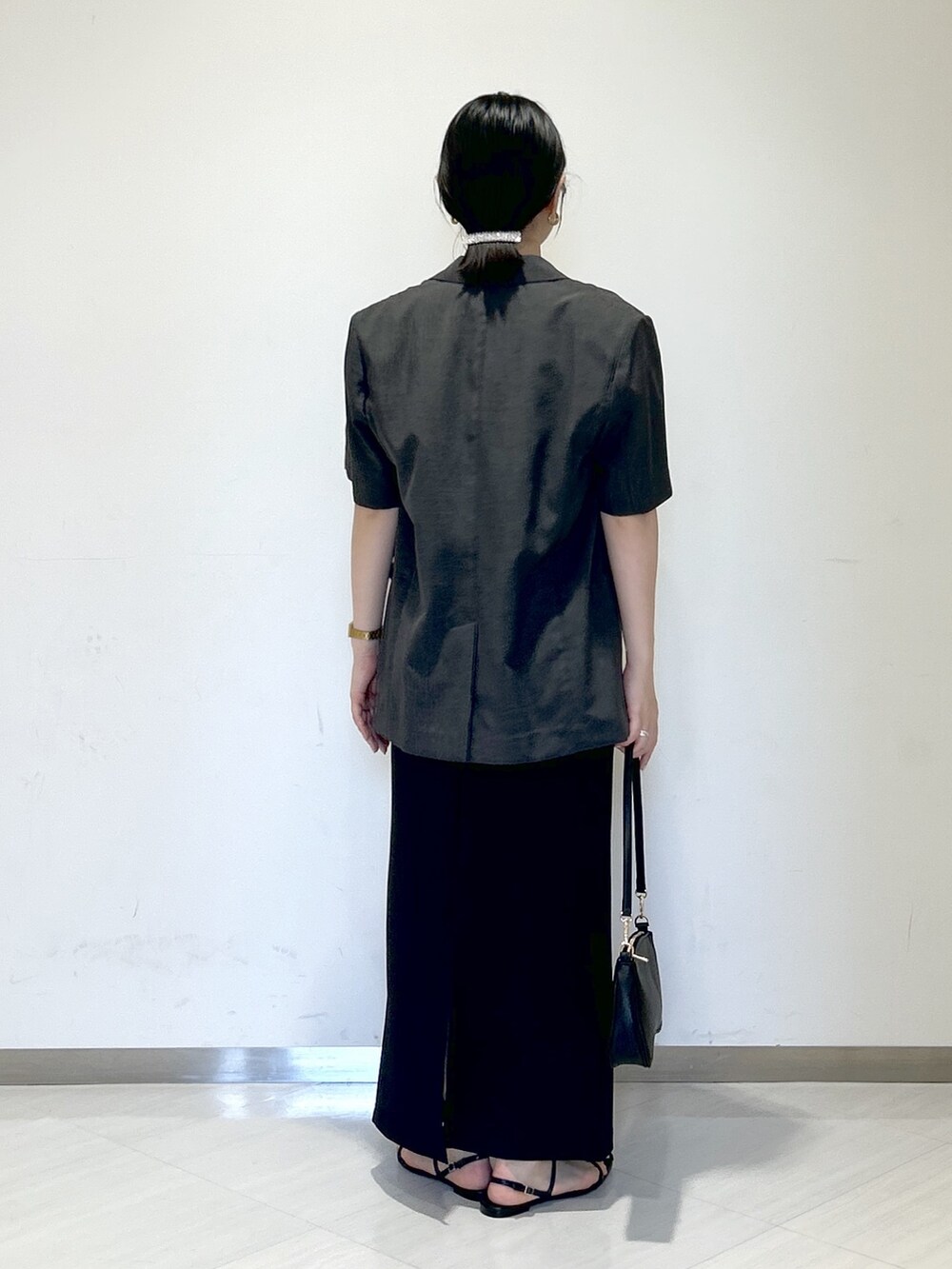 ホワイト系のシャツ/ブラウス、グレー系のテーラードジャケット、ブラック系のスカートを着用したレディースの夏コーディネートの4枚目の写真