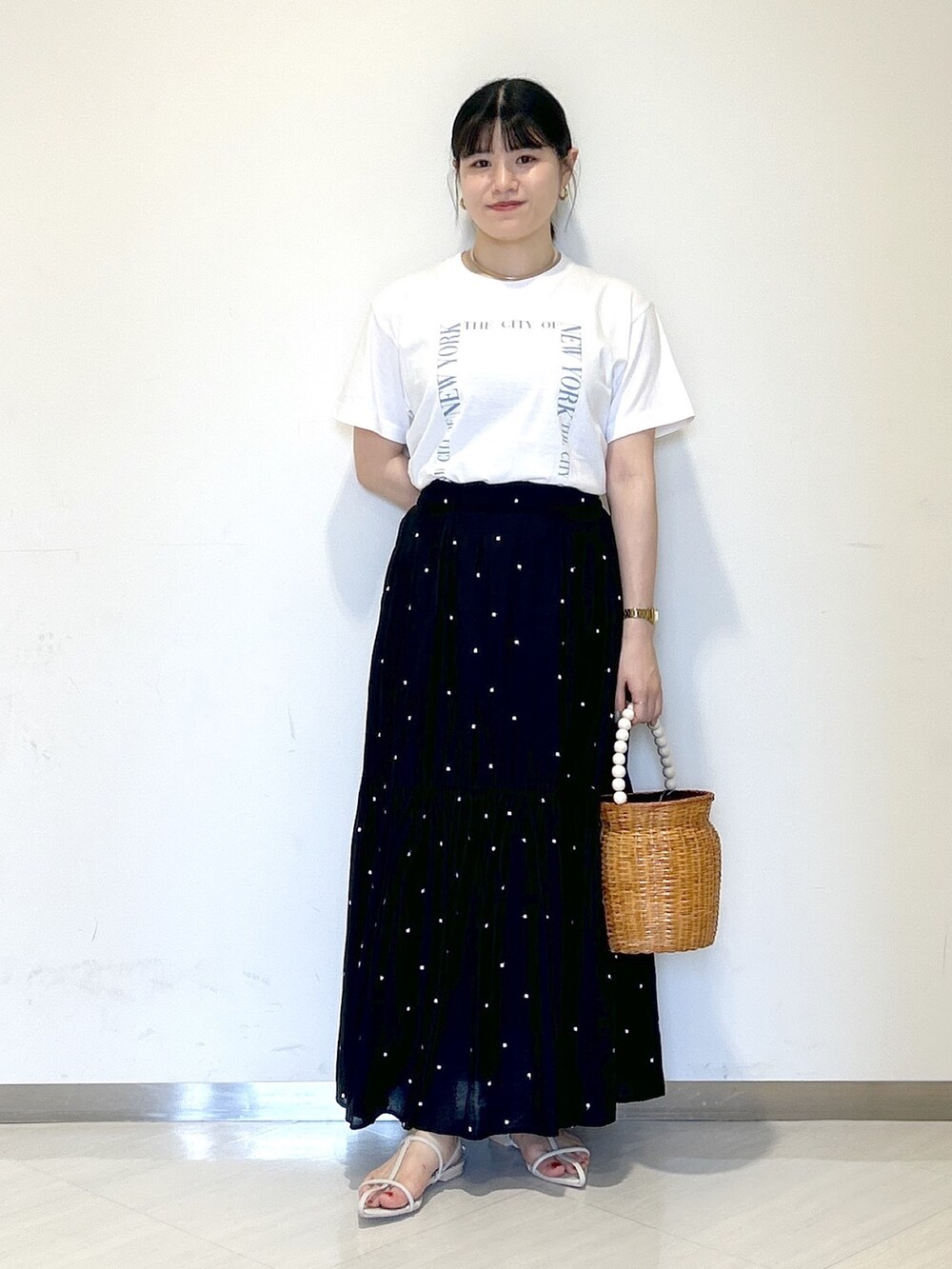 ホワイト系のTシャツ/カットソー、ブラック系のスカート、ブラウン系のかごバッグを着用したレディースの夏コーディネートの6枚目の写真