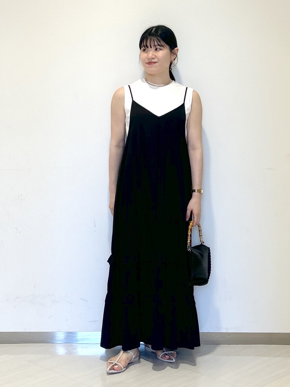 ブラック系のワンピース、ブラック系のショルダーバッグ、ホワイト系のサンダルを着用したレディースの夏コーディネートの5枚目の写真