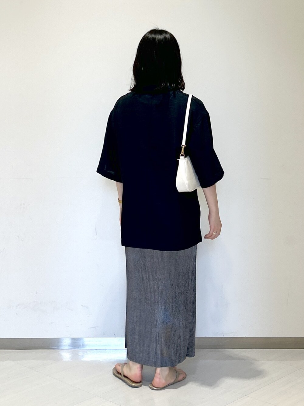 ブラック系のタンクトップ、ホワイト系のショルダーバッグ、ブラック系のテーラードジャケットを着用したレディースの夏コーディネートの3枚目の写真