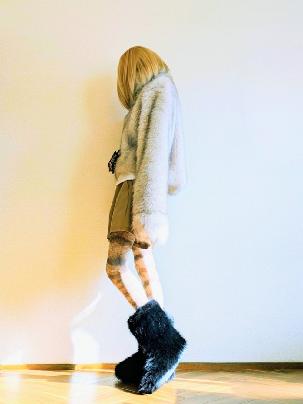 ベージュ系のトップス、ホワイト系のハンドバッグ、ブラウン系のポーチを着用したレディースの冬コーディネートの2枚目の写真