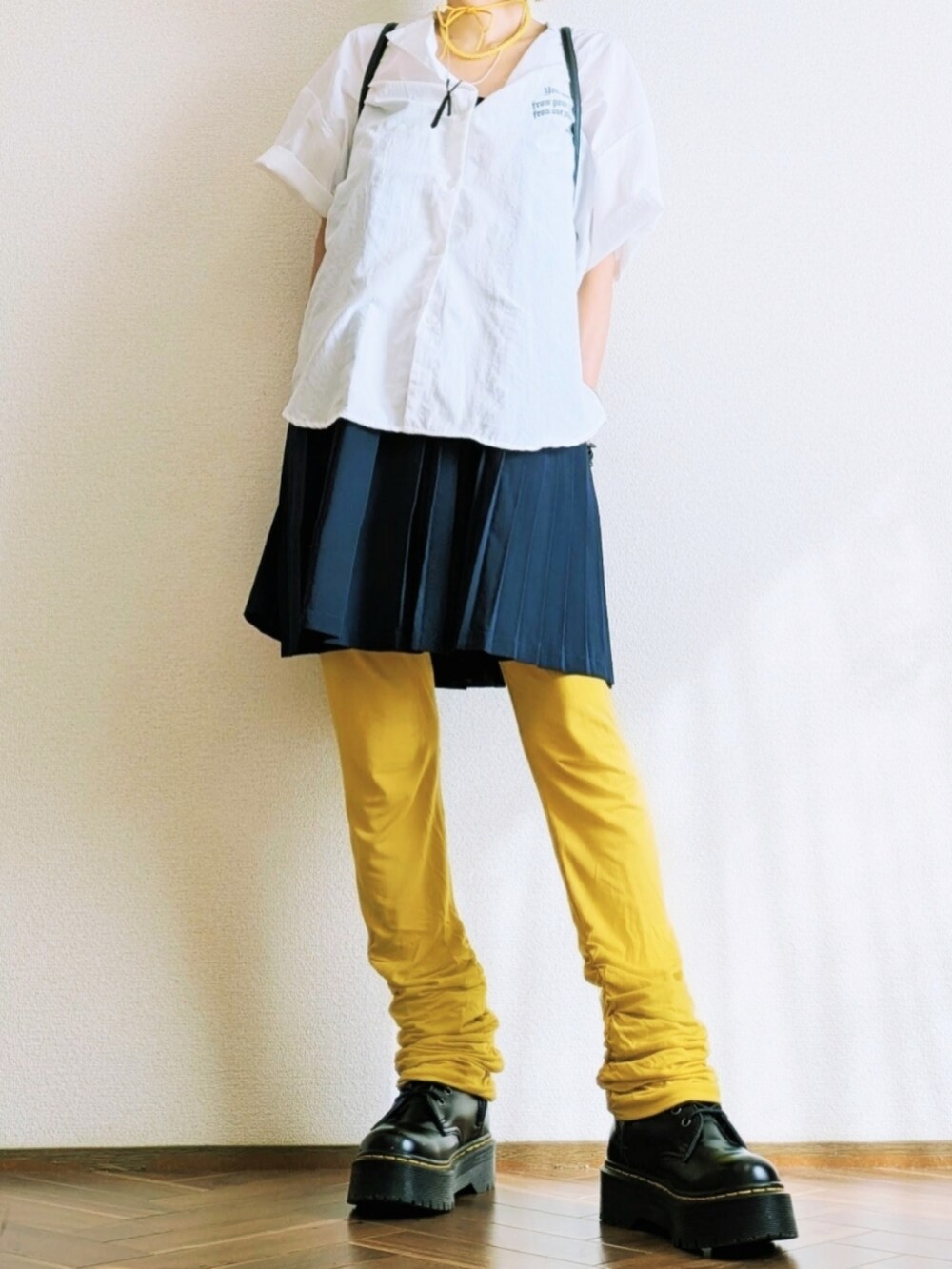 ホワイト系のシャツ/ブラウス、ブルー系のスカート、ブラック系のバックパック/リュックを着用したレディースの秋コーディネートの2枚目の写真