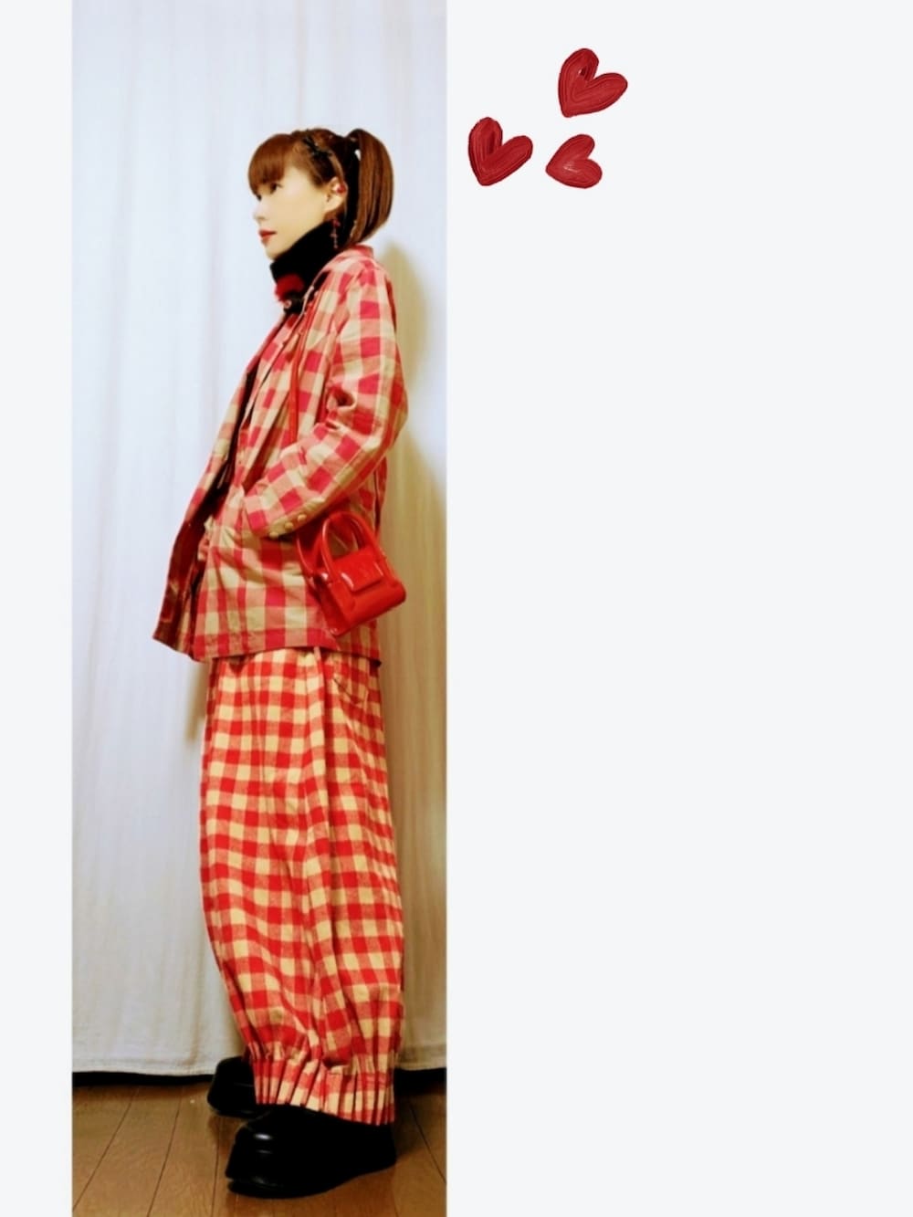 レッド系のバッグ、レッド系のテーラードジャケット、レッド系のパンツを着用したレディースの冬コーディネートの2枚目の写真