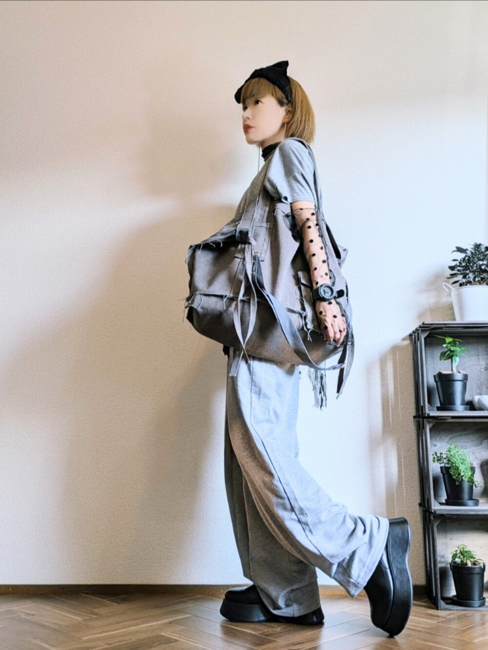 グレー系のTシャツ/カットソー、グレー系のパンツ、グレー系のショルダーバッグを着用したレディースの秋コーディネートの2枚目の写真