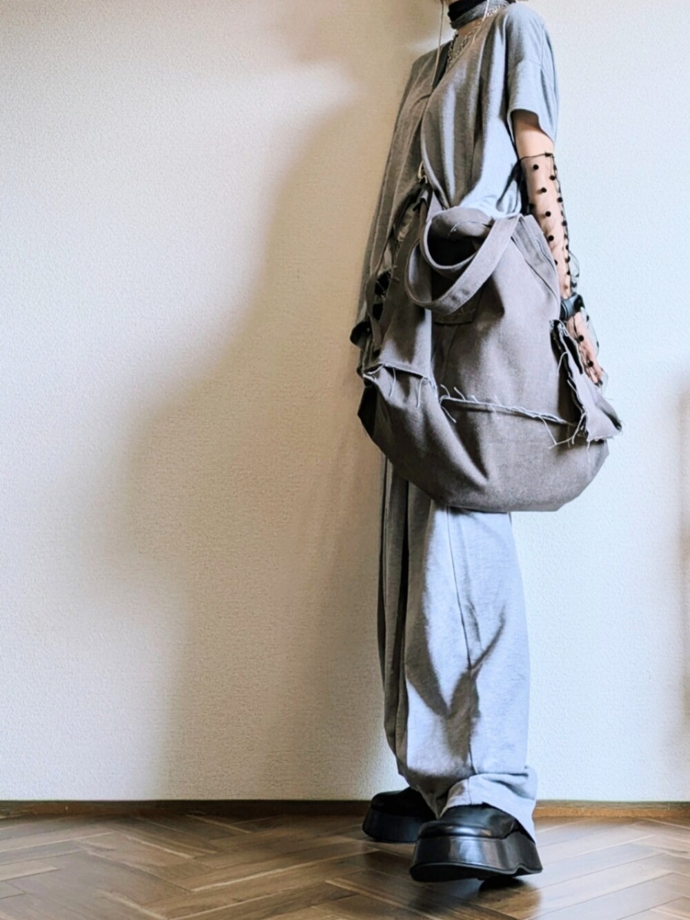 グレー系のTシャツ/カットソー、グレー系のパンツ、グレー系のショルダーバッグを着用したレディースの秋コーディネートの3枚目の写真