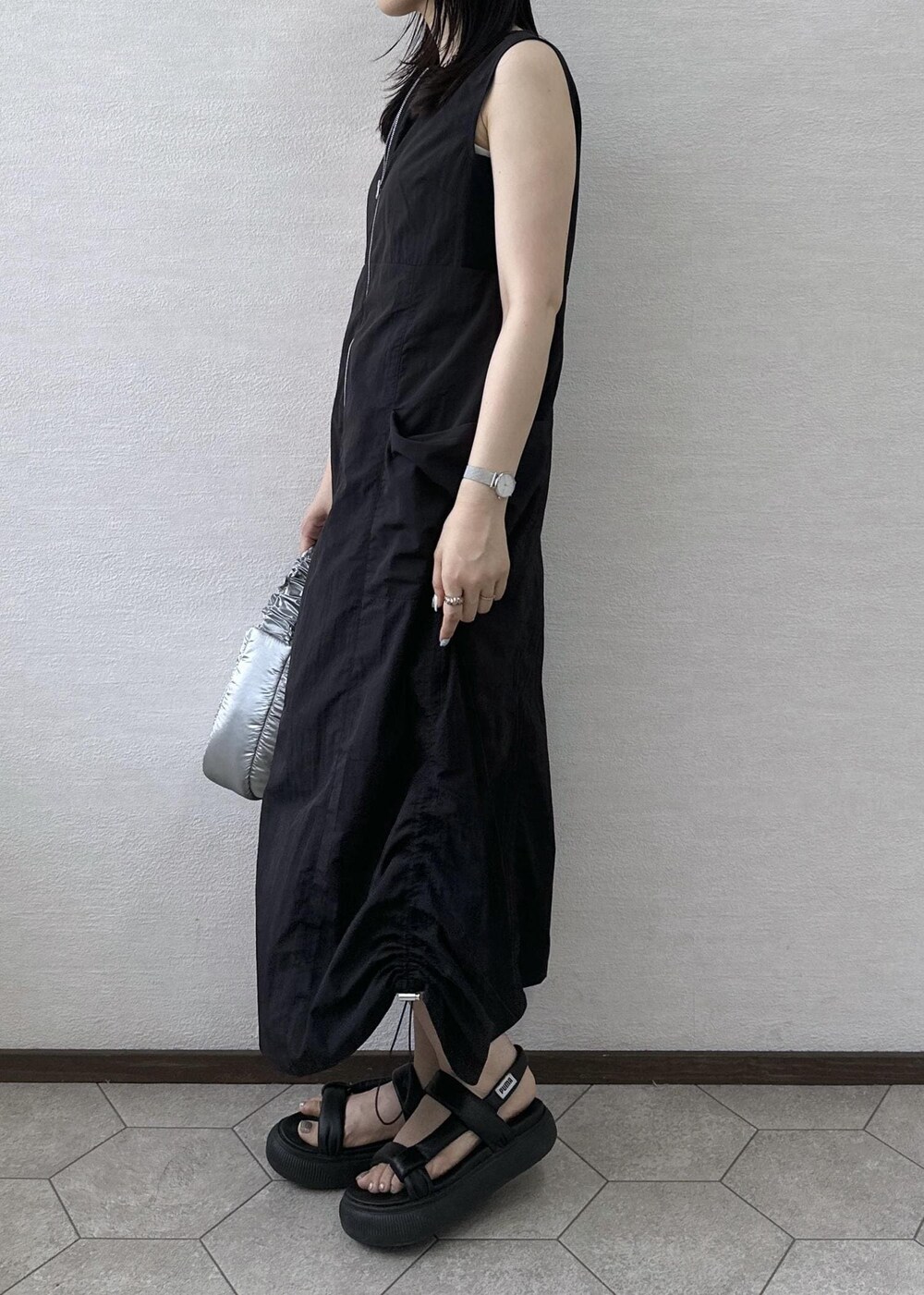 ブラック系のワンピース、シルバー系のショルダーバッグを着用したレディースの夏コーディネートの6枚目の写真